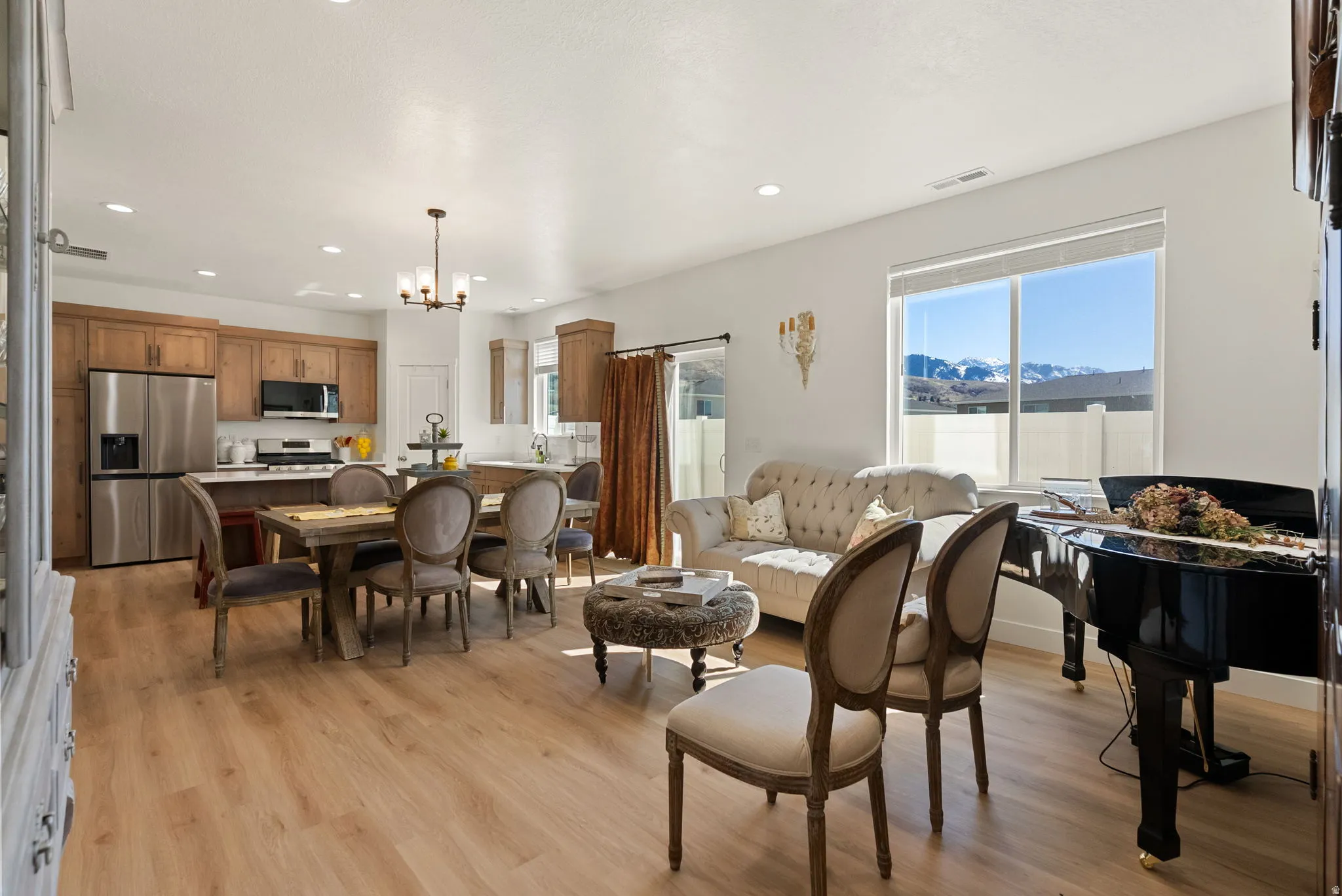 Living room with healthy amount of natural light, light wood-style flooring, and a chandelier