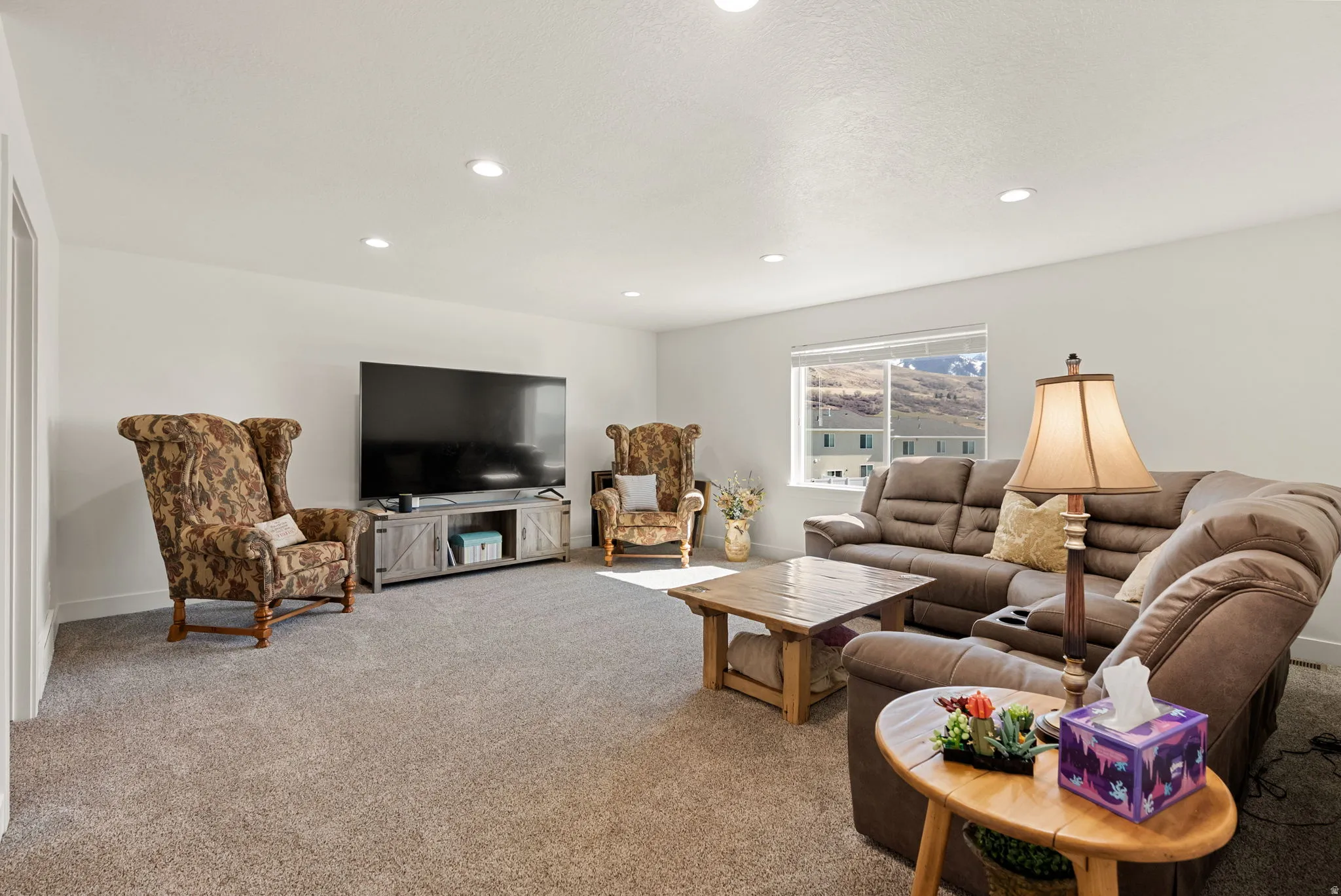Carpeted living area featuring recessed lighting and baseboards
