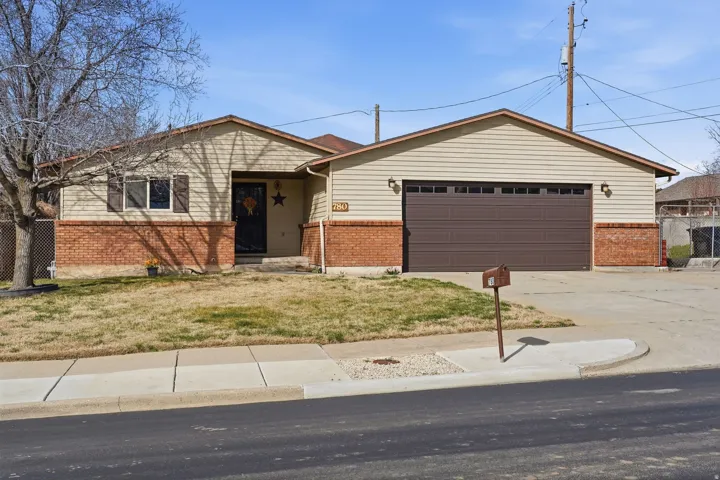 View of front of house with brick siding, a garage, and concrete driveway