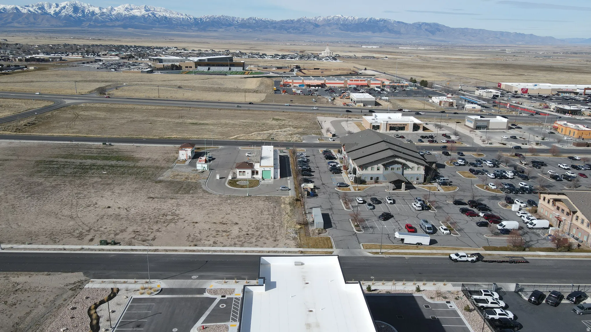 Aerial view of property and surrounding area with mountains and industrial structures