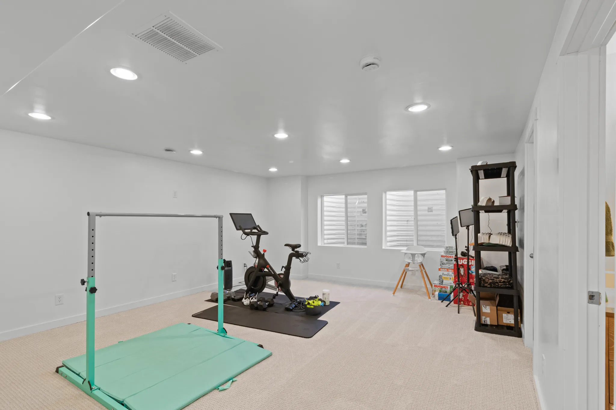 Workout room with light carpet and recessed lighting