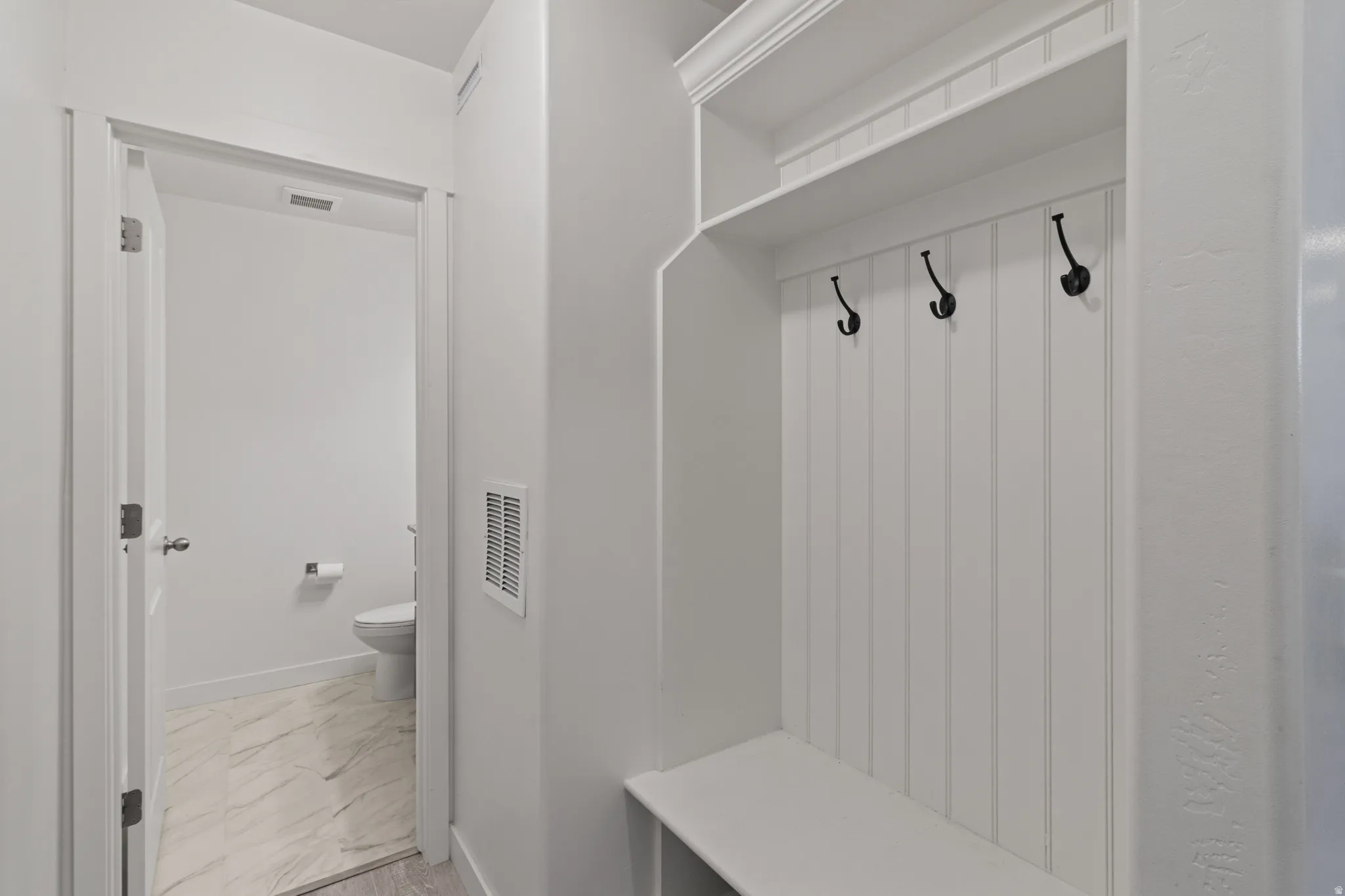 Mudroom with light marble finish flooring and baseboards