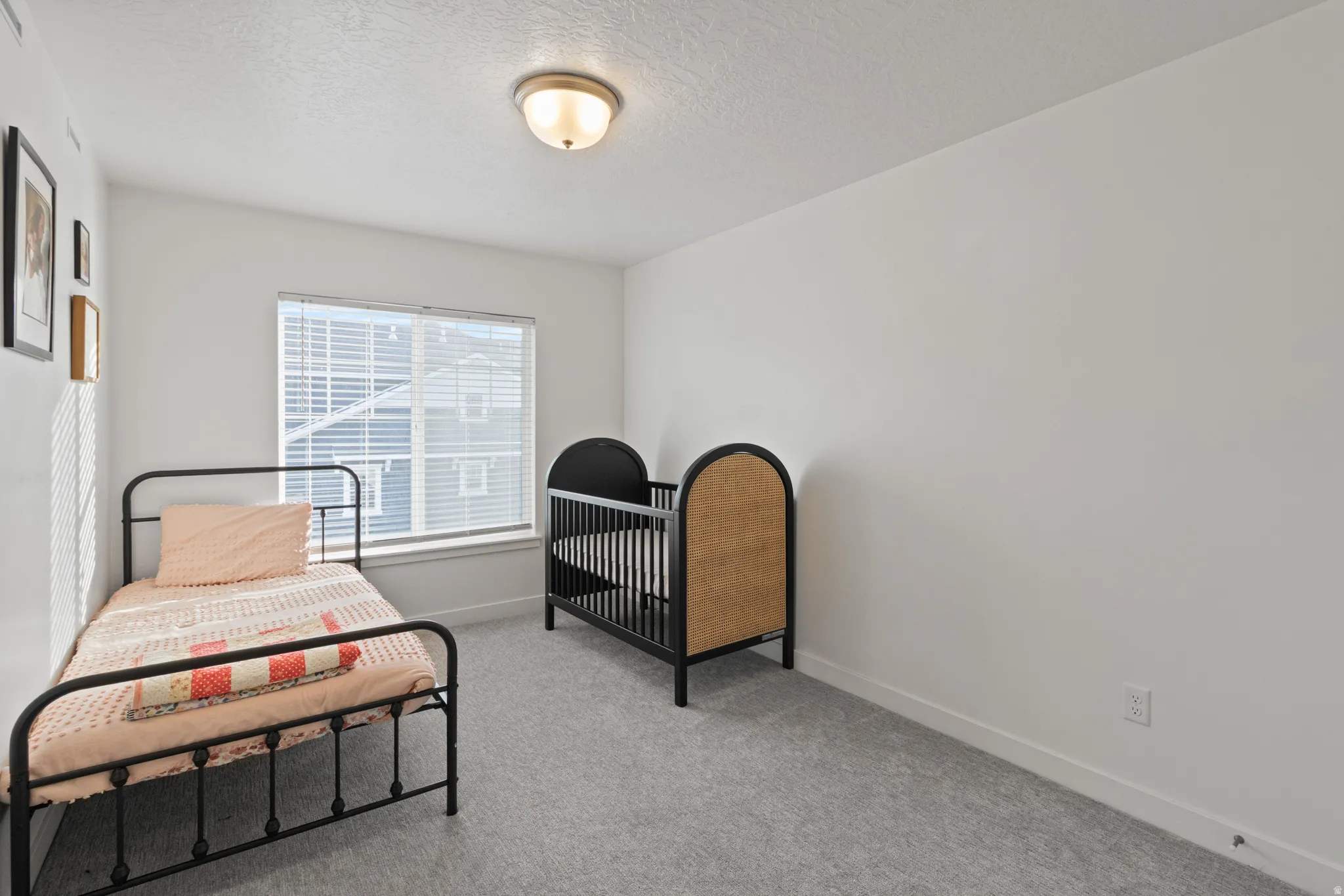 Bedroom featuring light colored carpet and a textured ceiling