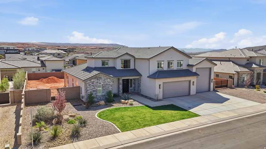 View of front of house featuring a residential view, driveway, stucco siding, an attached garage, and a gate