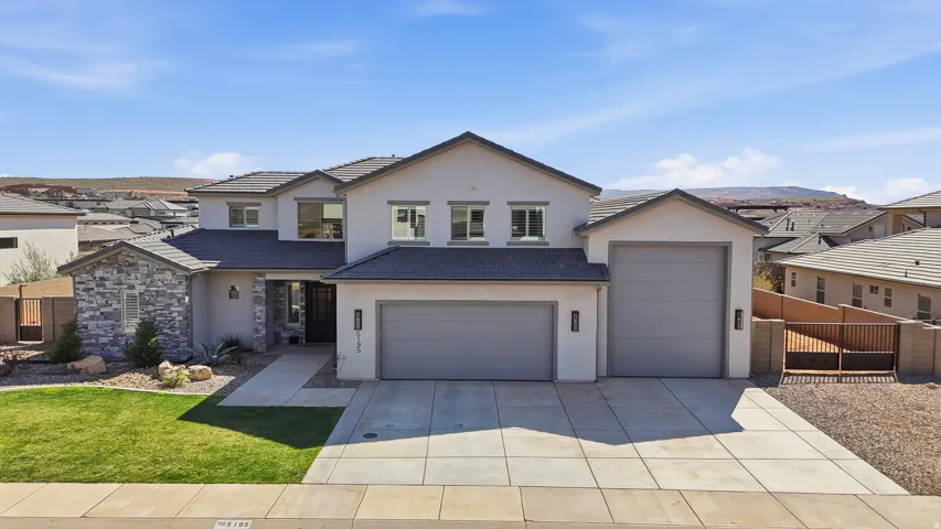 View of front facade featuring stucco siding, concrete driveway, and a residential view