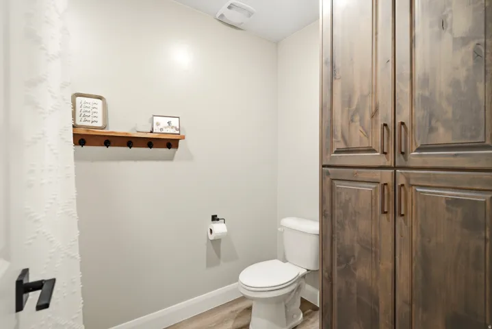 Bathroom featuring toilet and light wood finished floors