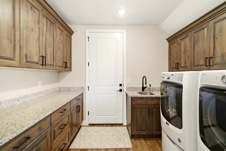 Laundry area featuring cabinet space, washing machine and dryer, light wood-style flooring, and lofted ceiling