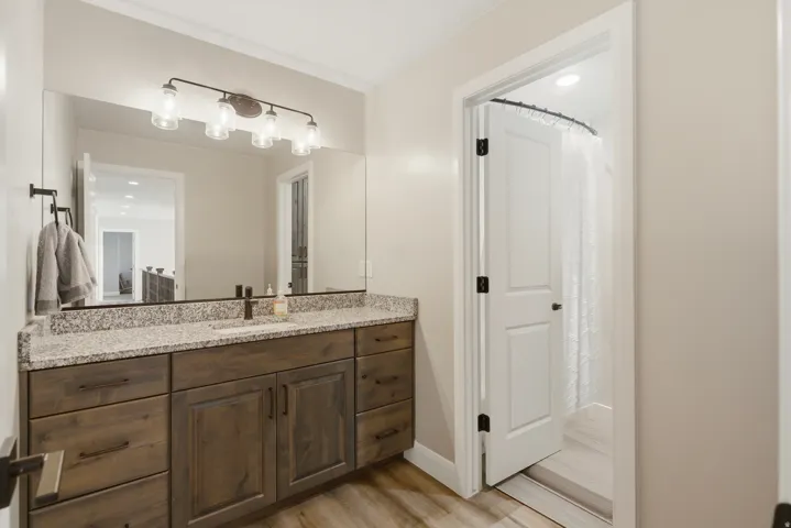 Full bathroom featuring vanity, a shower with curtain, light wood finished floors, and recessed lighting