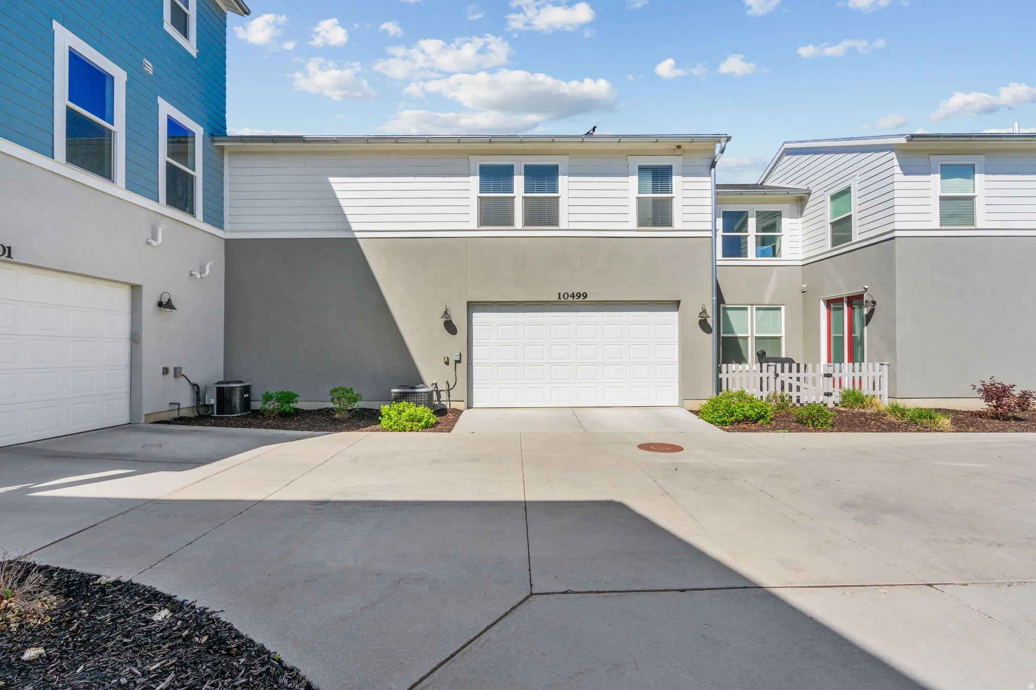View of front of house with stucco siding, an attached garage, and driveway