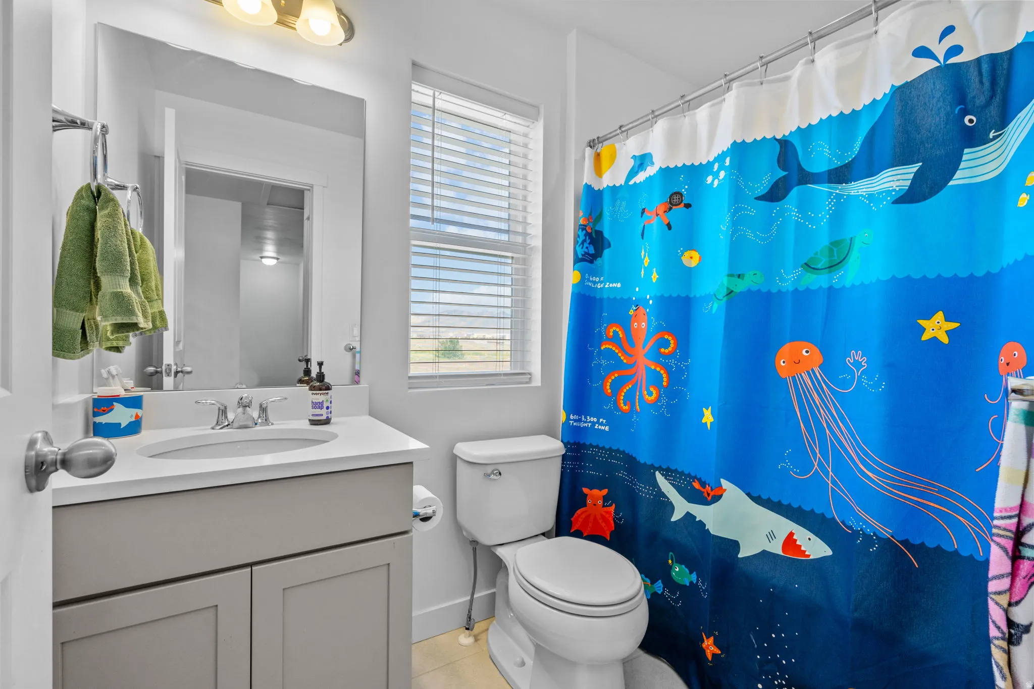 Bathroom with vanity, a shower with curtain, and light tile patterned floors