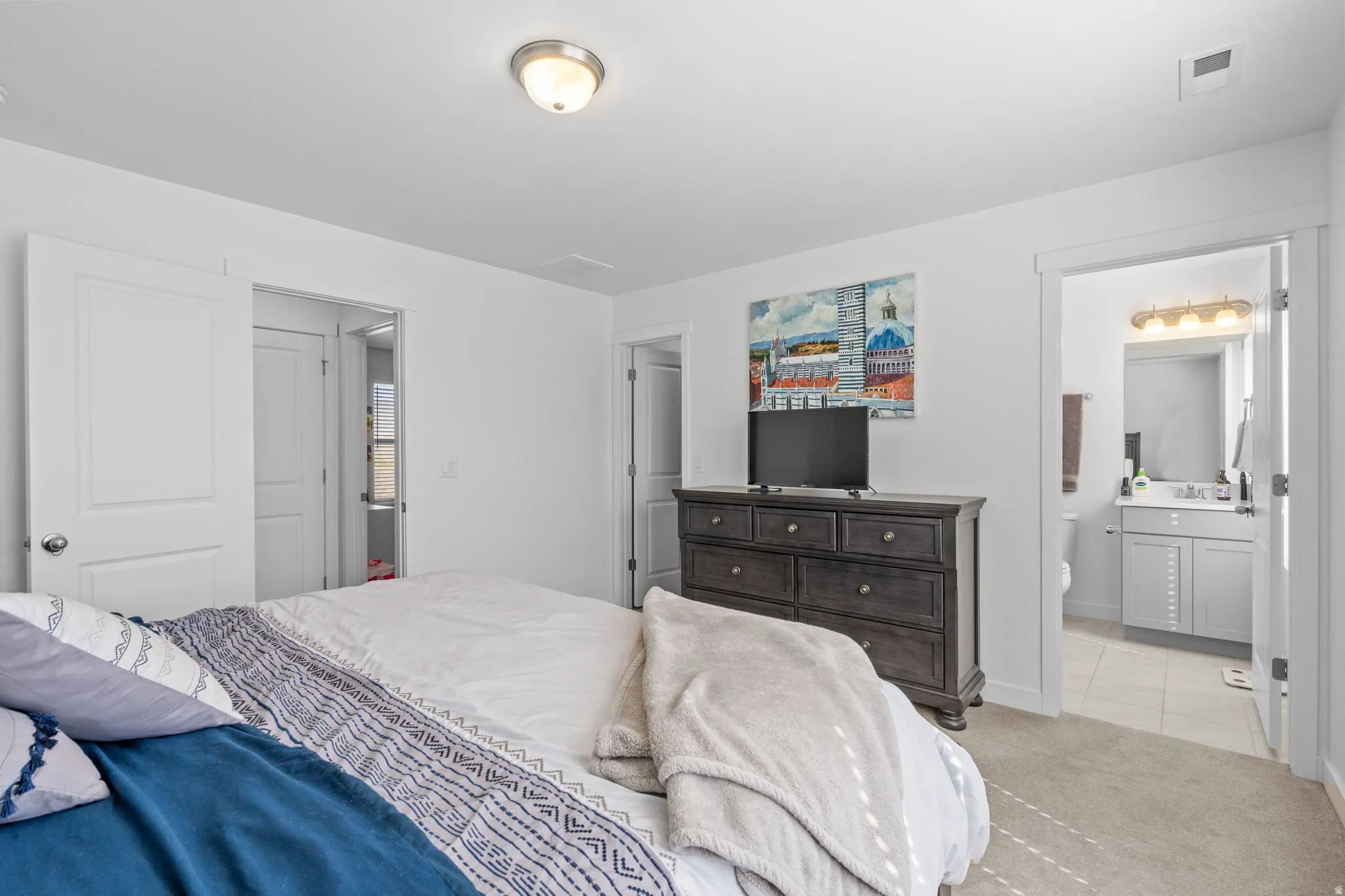 Bedroom with carpet floors and ensuite bathroom