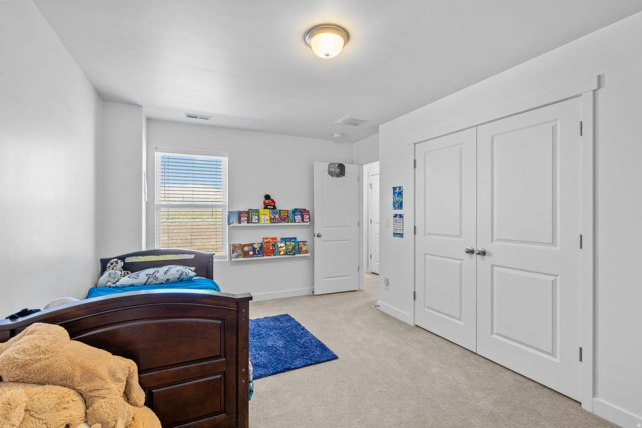 Bedroom with light carpet and a closet