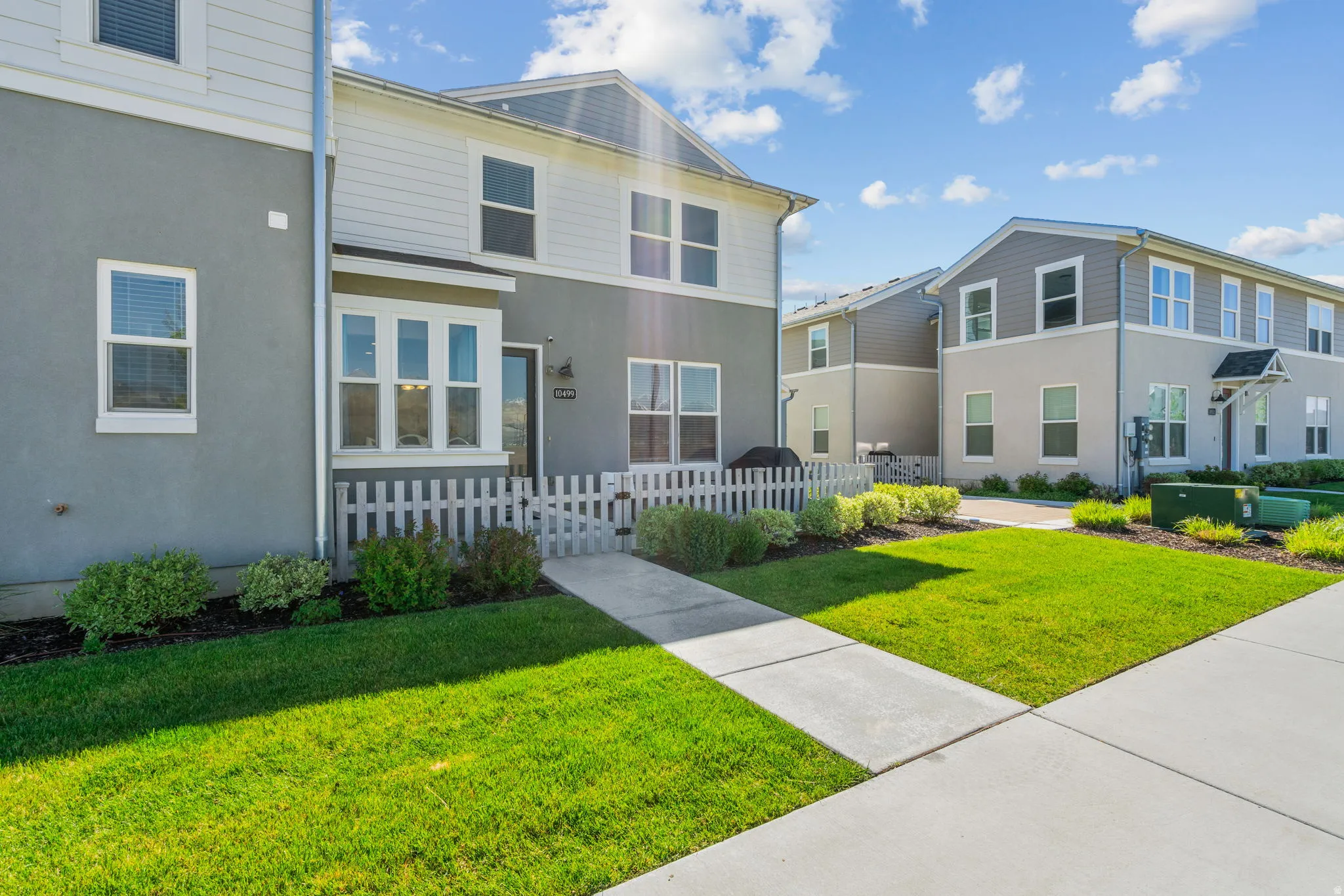 View of front of home with a fenced front yard, stucco siding, and a gate