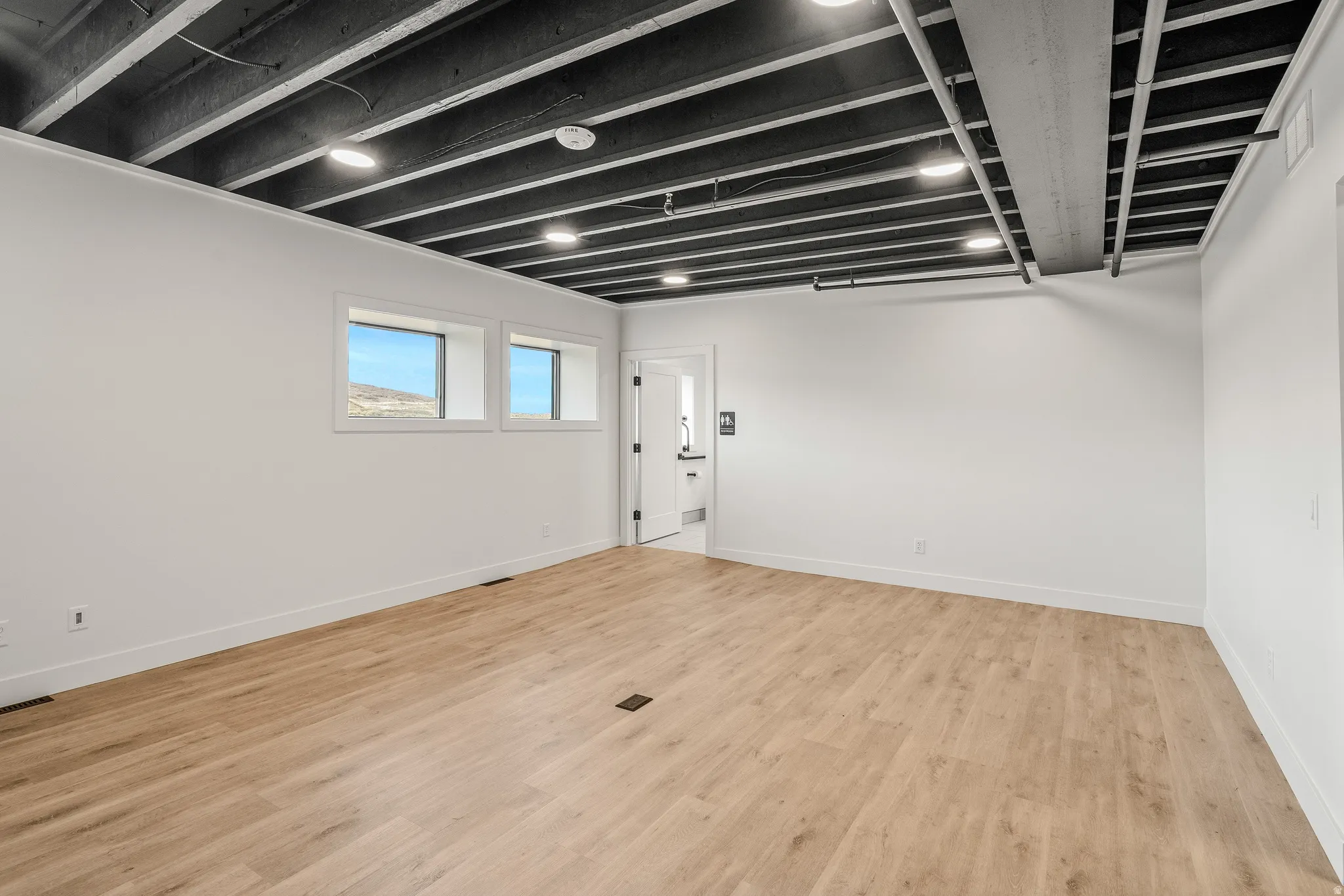 Below grade area featuring light wood-style flooring and baseboards