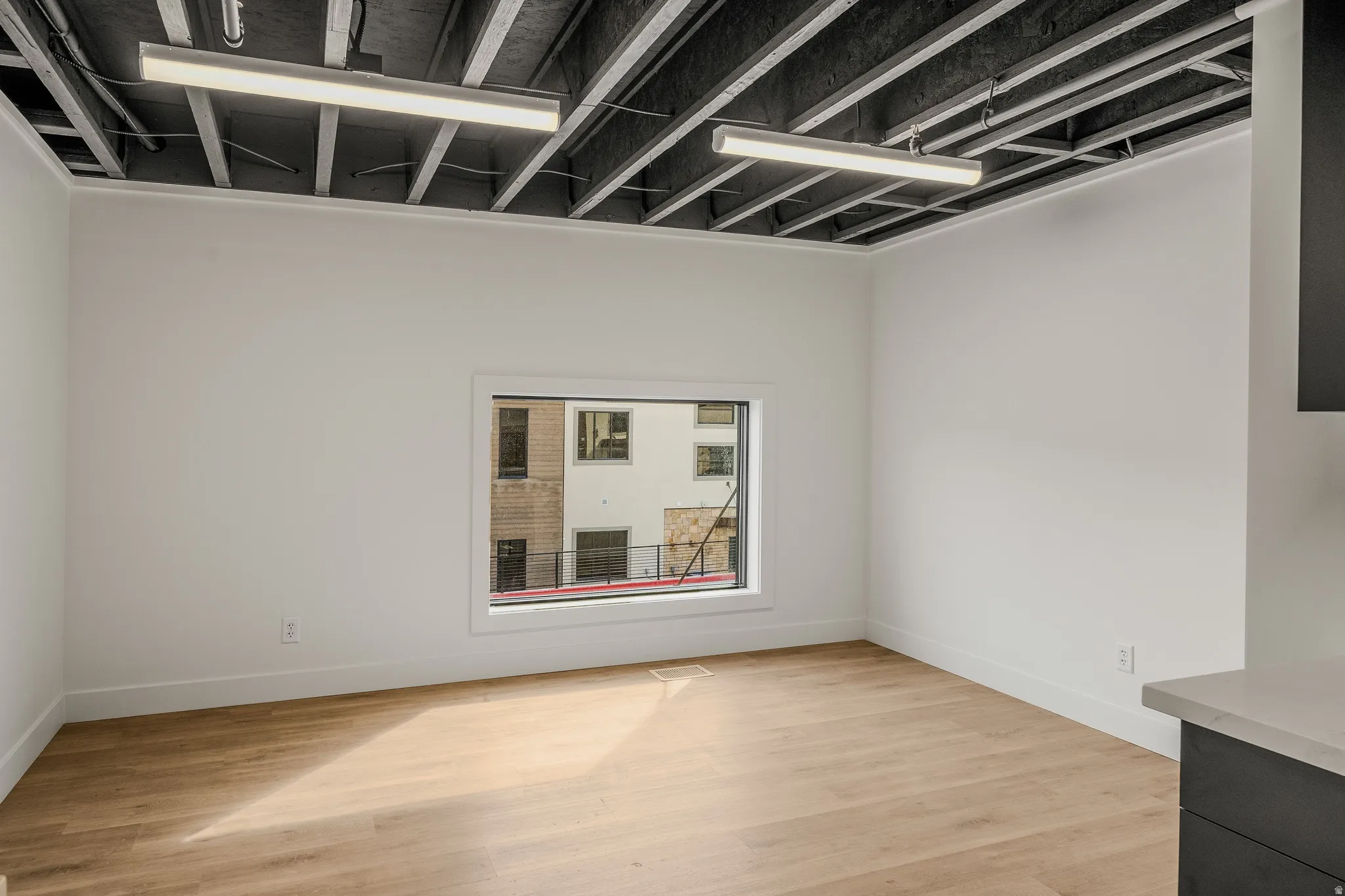 Spare room with light wood-style floors and baseboards