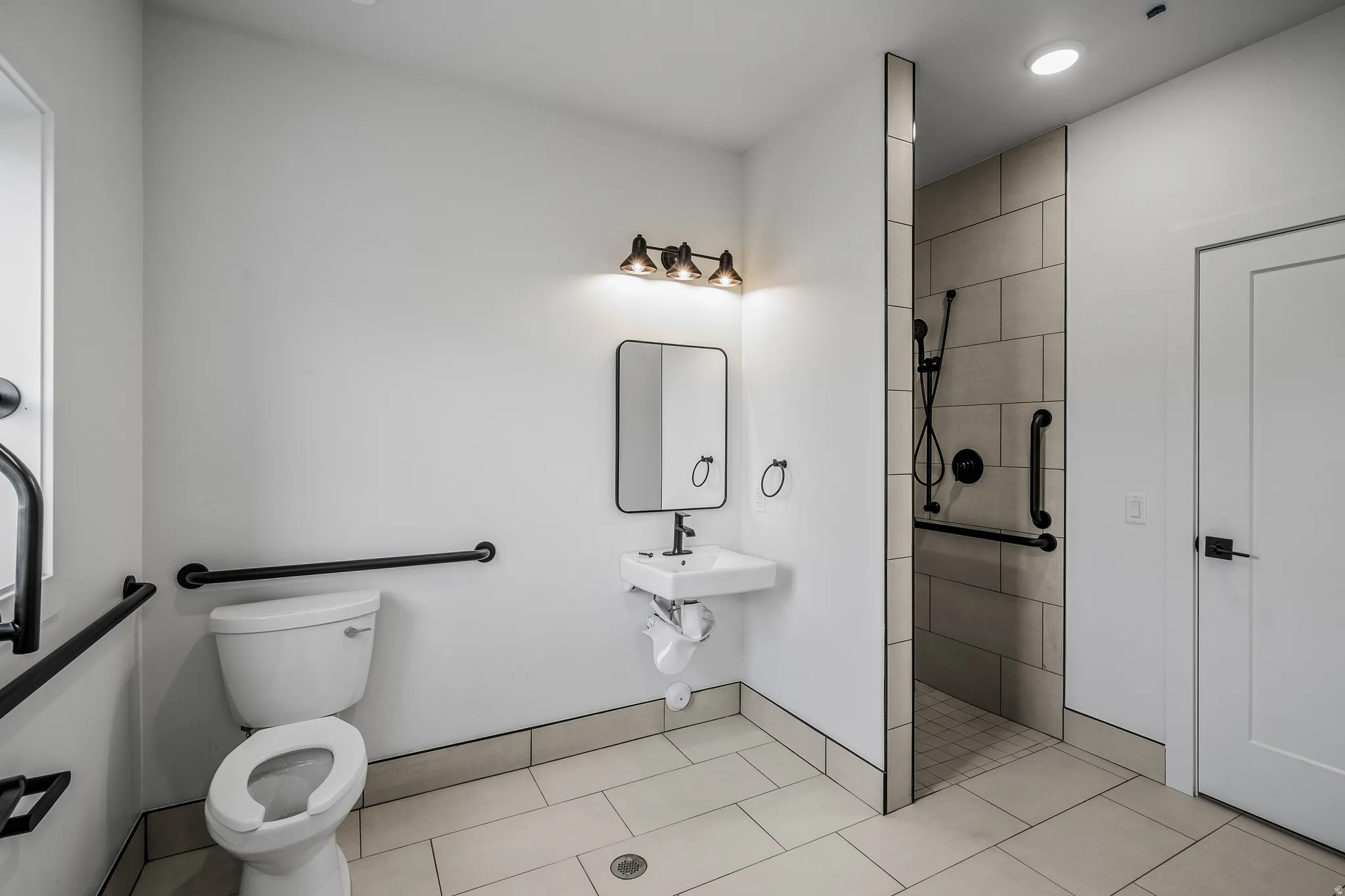 Bathroom with a tile shower, light tile patterned flooring, and recessed lighting