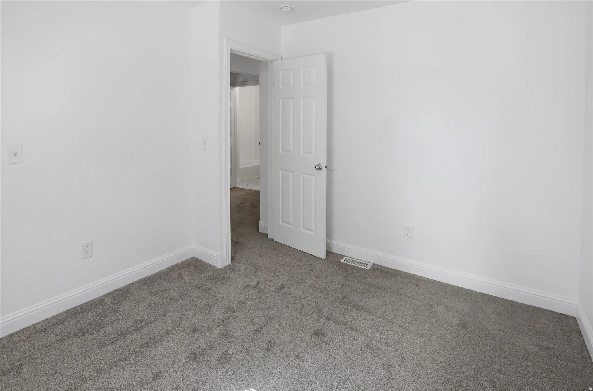 Unfurnished room featuring light colored carpet and baseboards