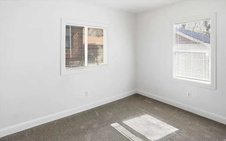 Carpeted empty room featuring baseboards