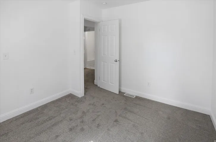 Unfurnished room featuring light colored carpet and baseboards