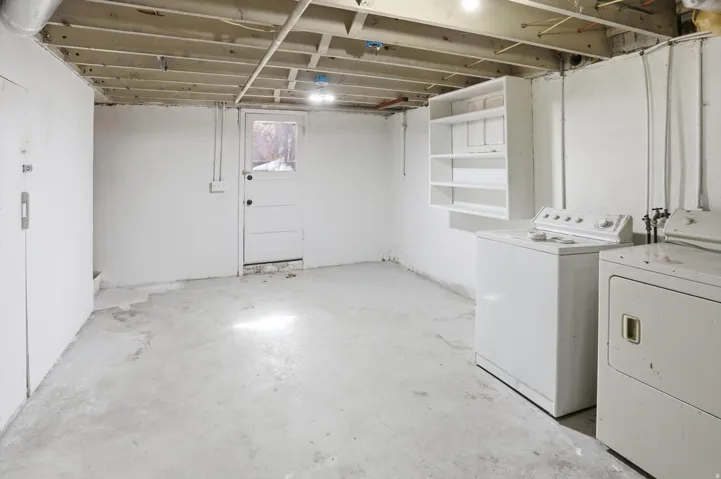 Unfinished below grade area featuring washer and clothes dryer