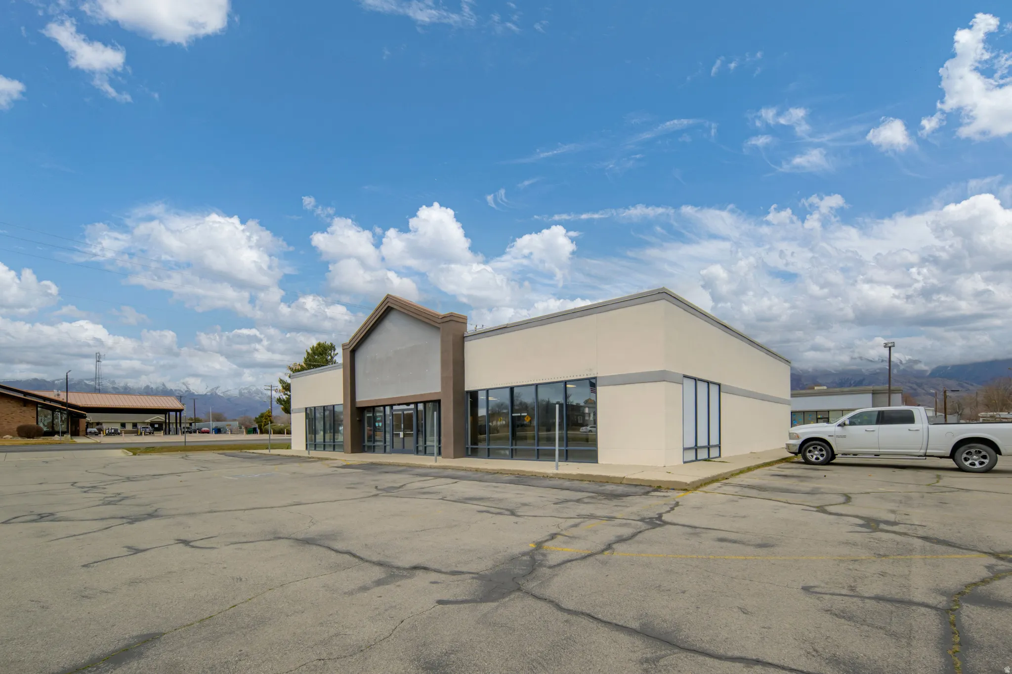 View of commercial property with uncovered parking and a mountain view