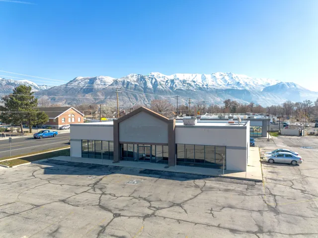 View of property with a mountain view and uncovered parking