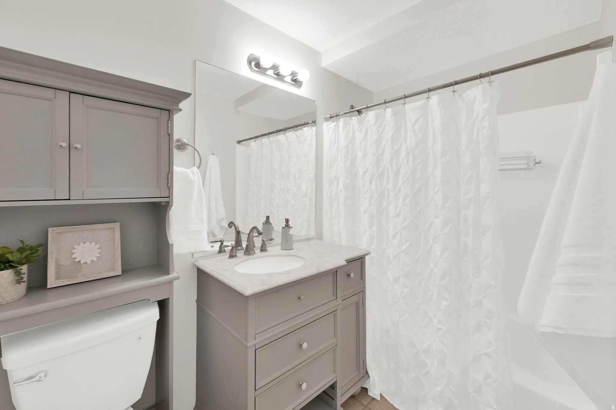 Bathroom with vanity and curtained shower