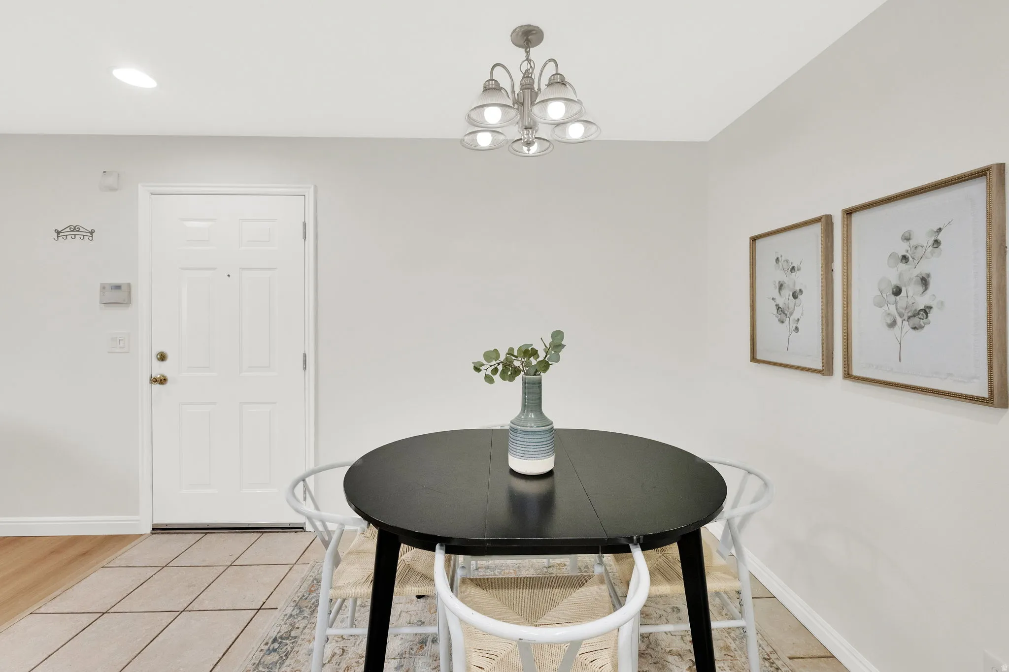 Dining space featuring light tile patterned flooring and a chandelier