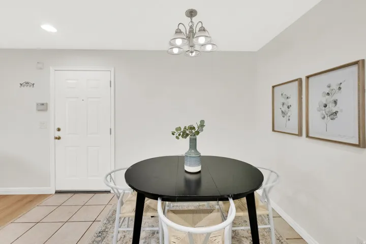 Dining space featuring light tile patterned flooring and a chandelier