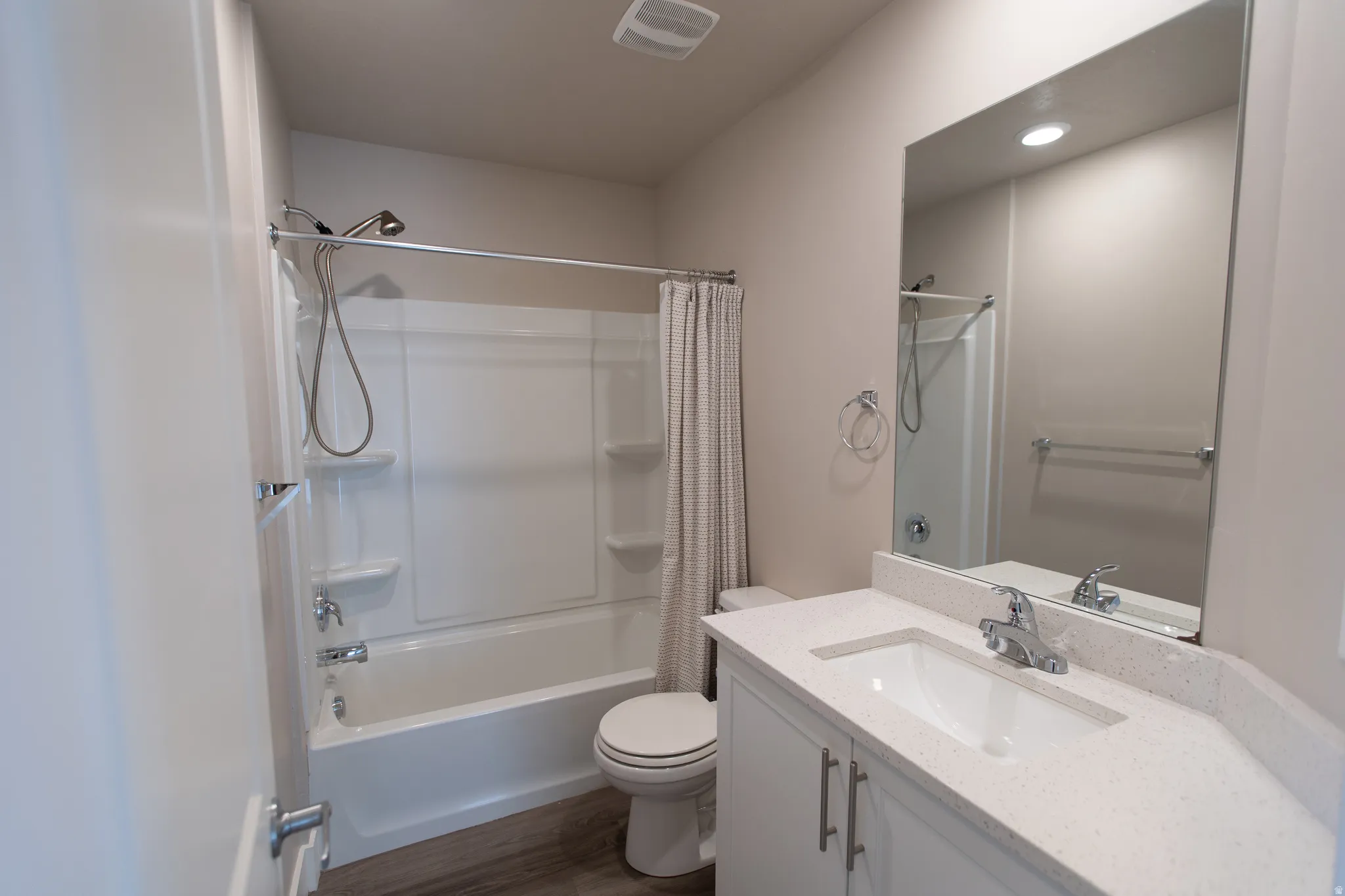 Full bathroom featuring vanity, shower / bath combo with shower curtain, and dark wood finished floors