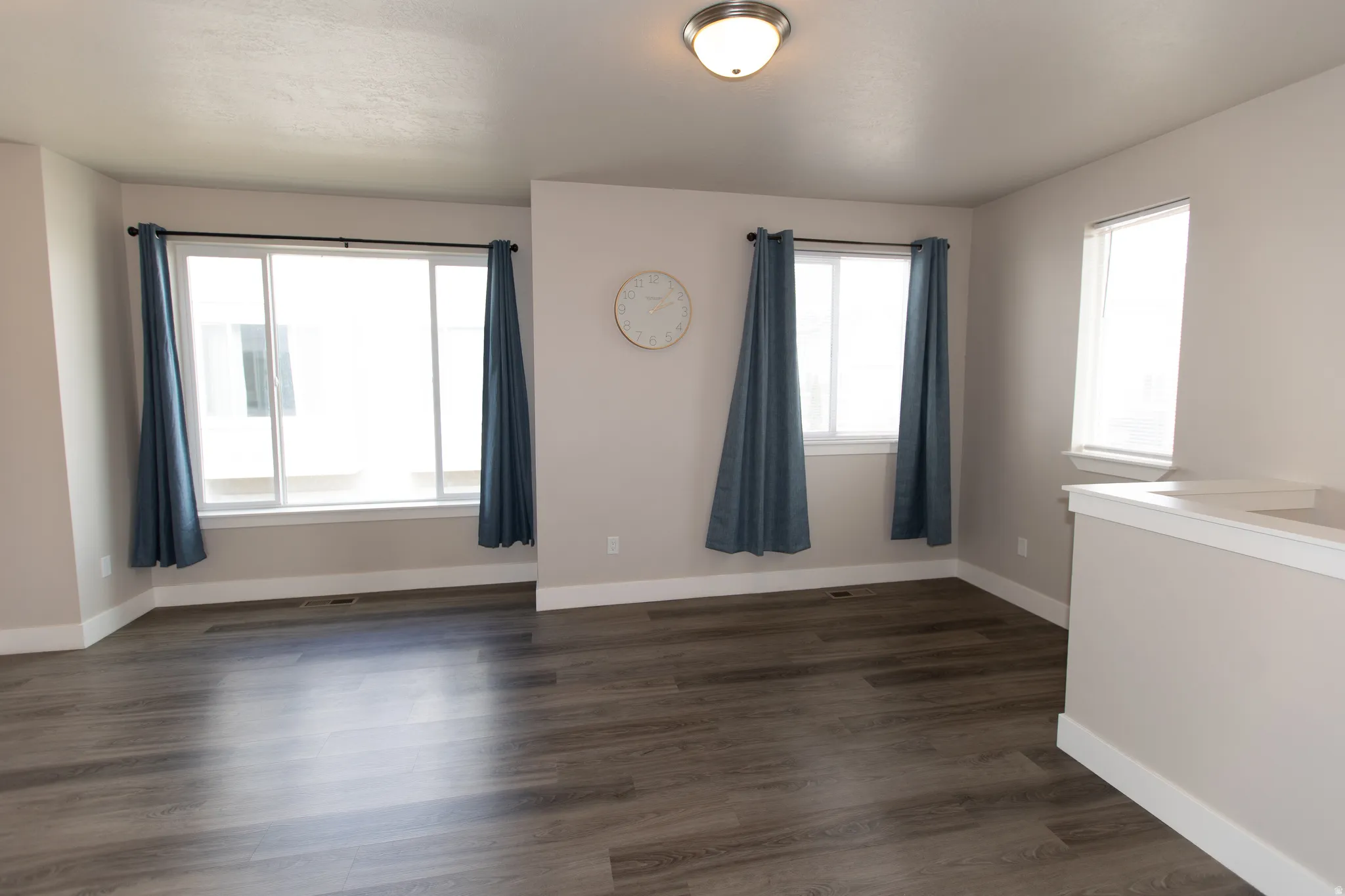 Empty room with dark wood-style floors and baseboards