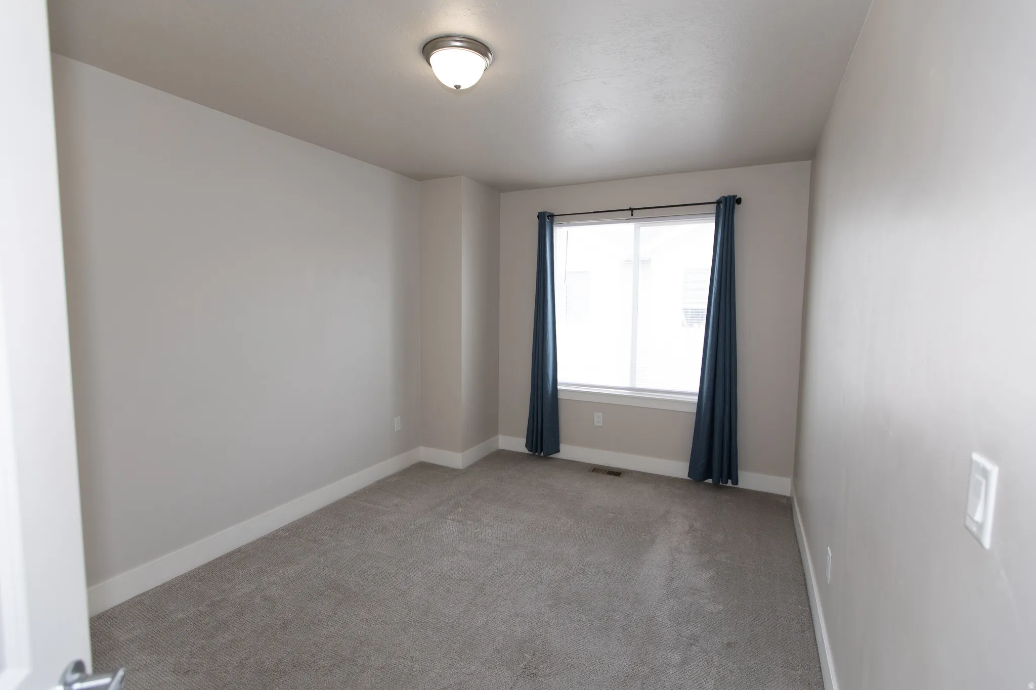 Unfurnished room with light colored carpet and baseboards