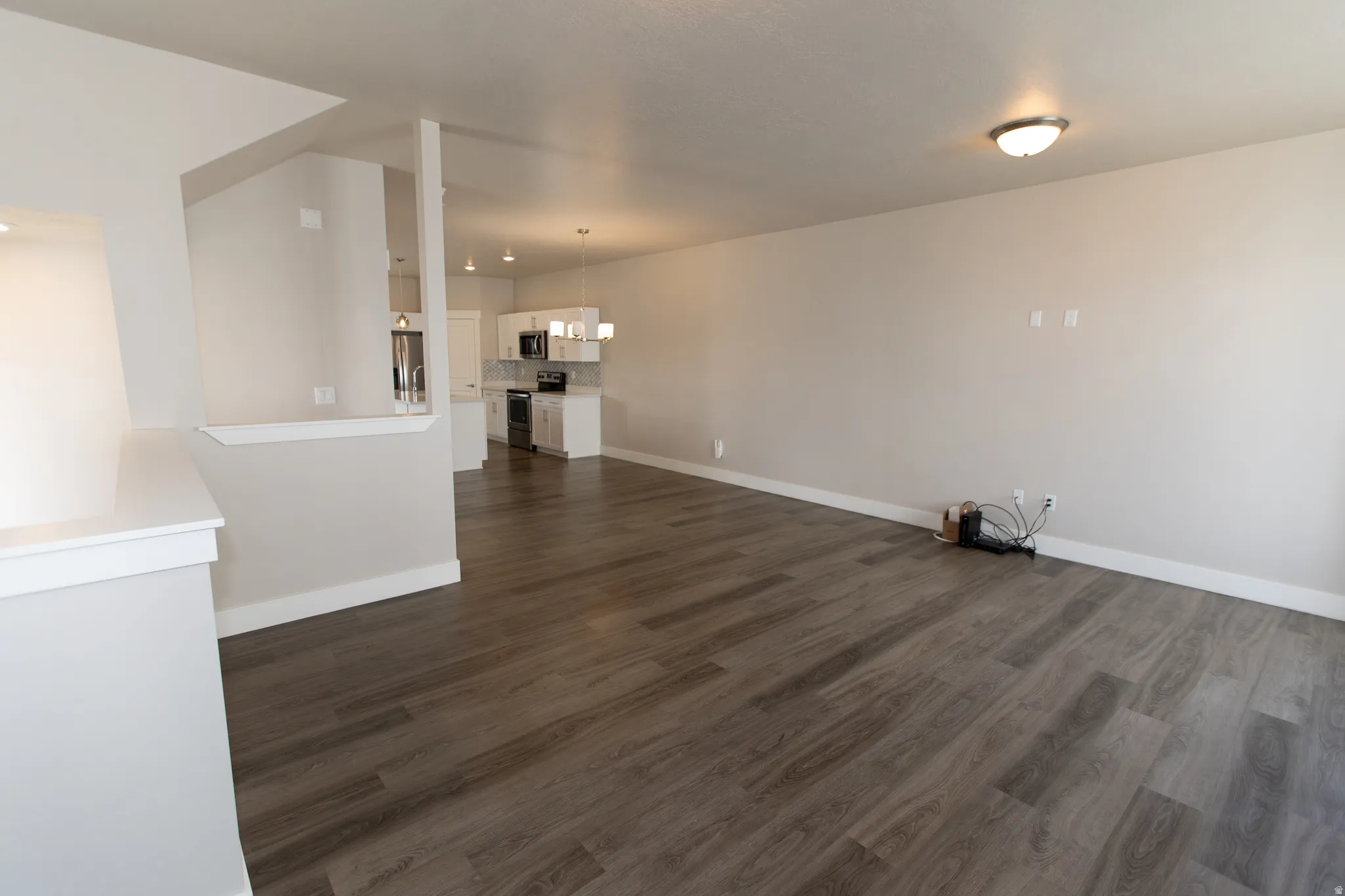 Unfurnished living room with dark wood-style flooring