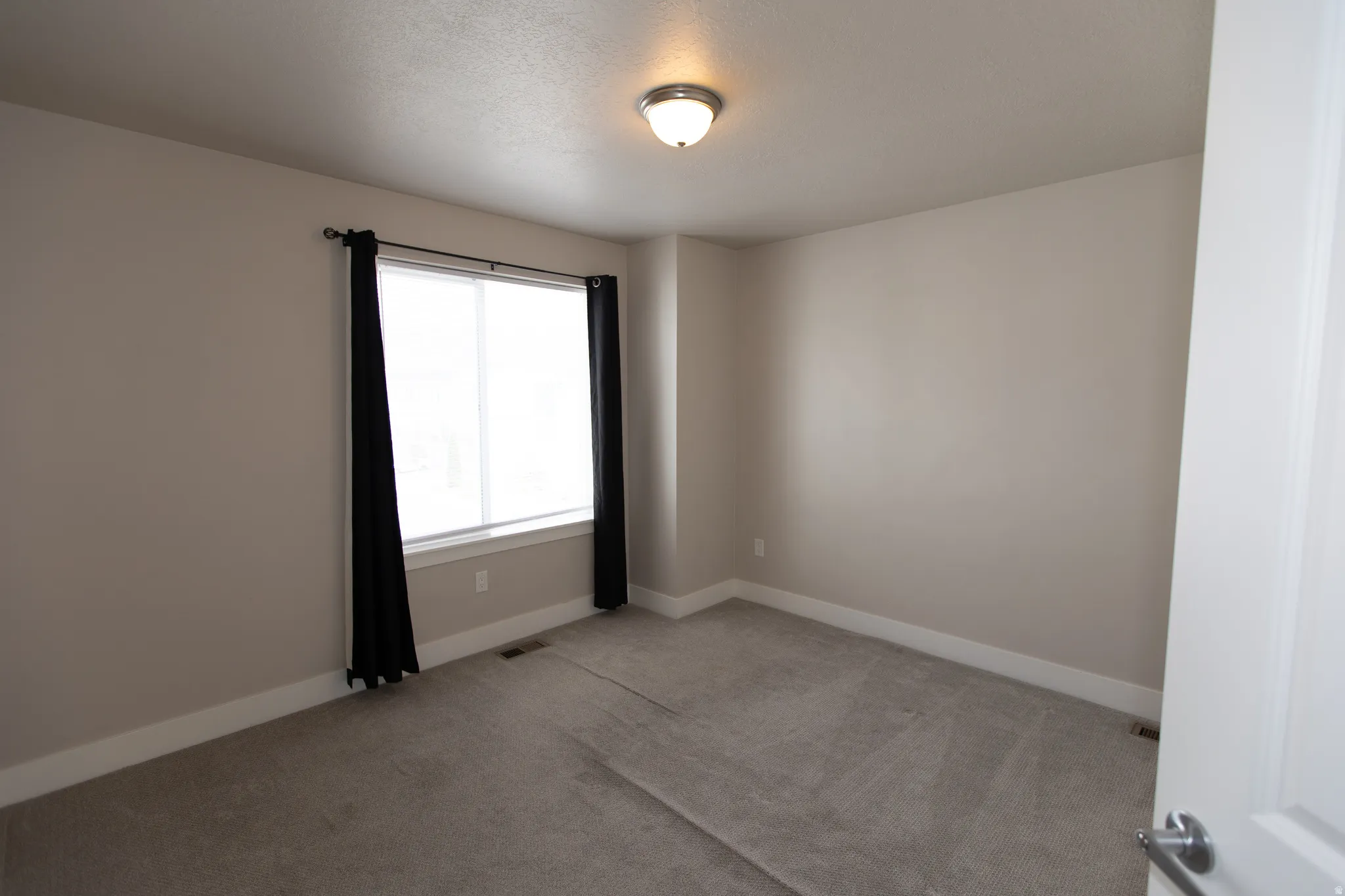 Unfurnished room with baseboards and light carpet