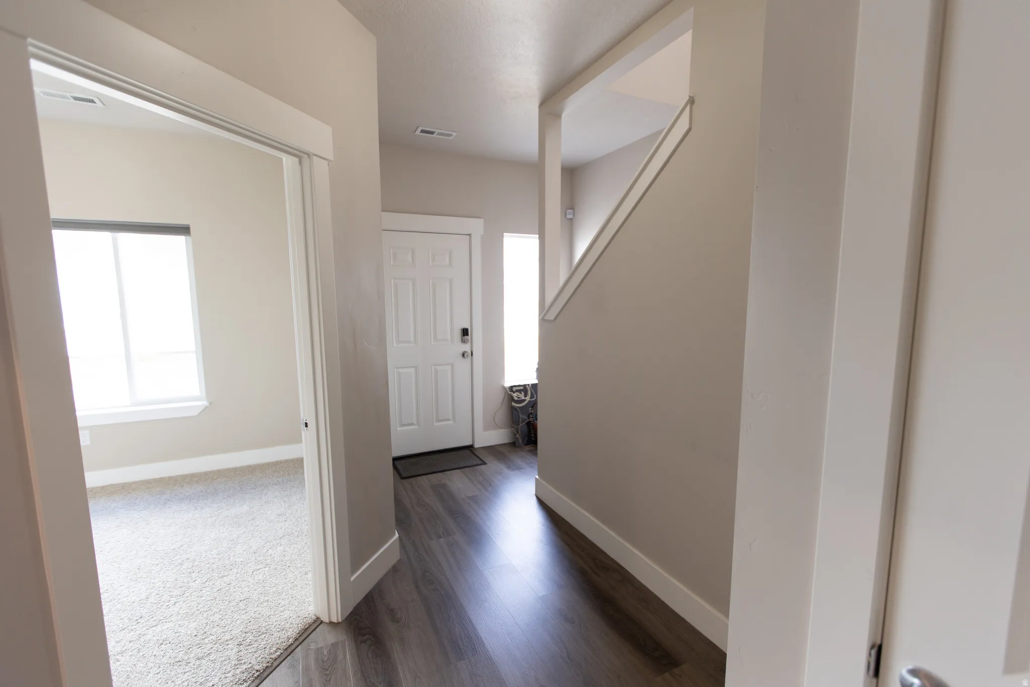 Corridor with dark wood-style floors and baseboards