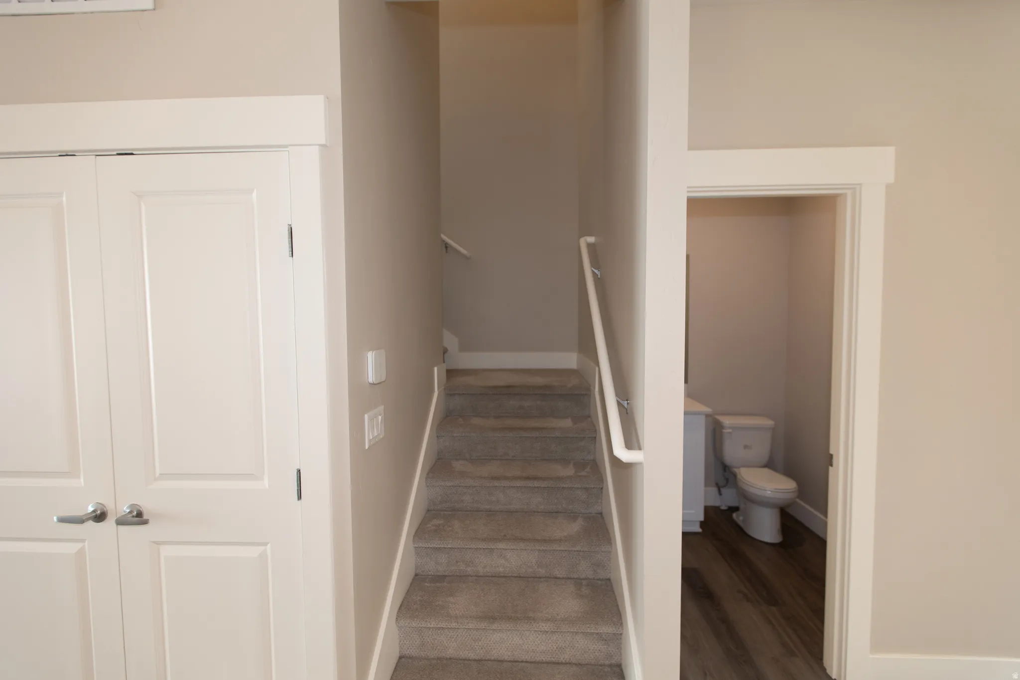 Stairs with wood finished floors and baseboards