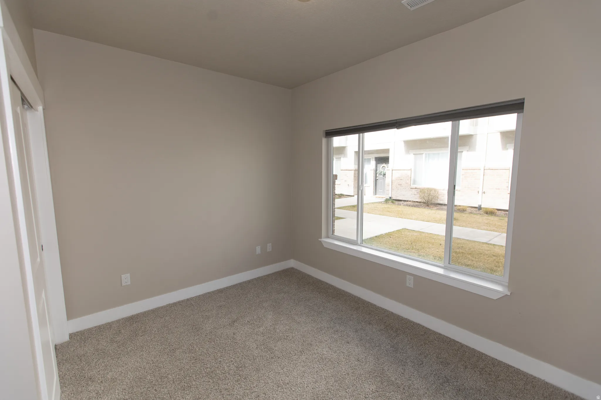 Unfurnished bedroom with light carpet and a closet