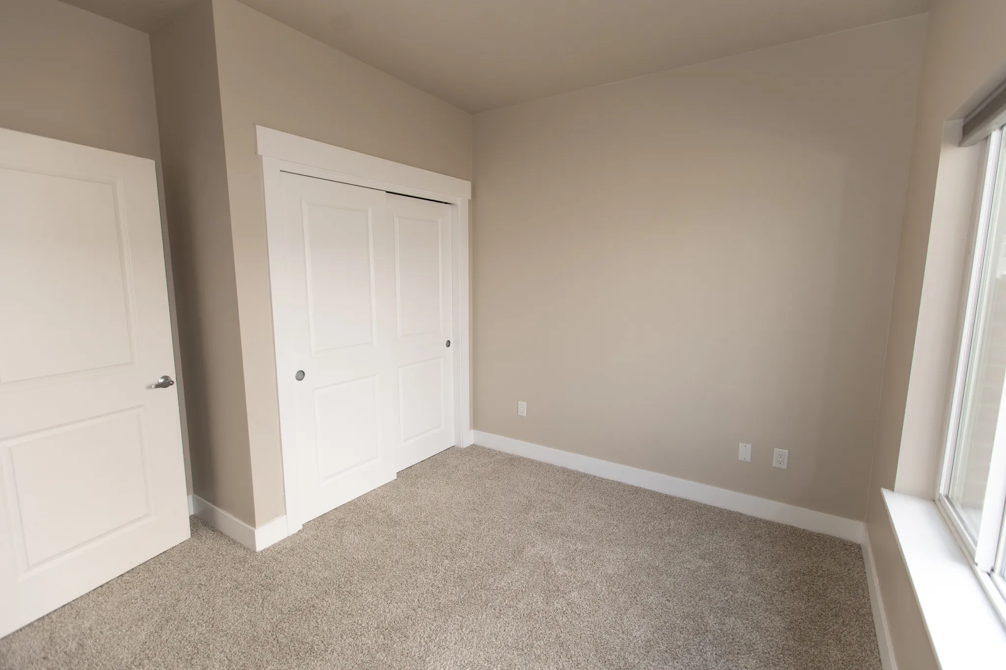 Unfurnished bedroom featuring light colored carpet and a closet