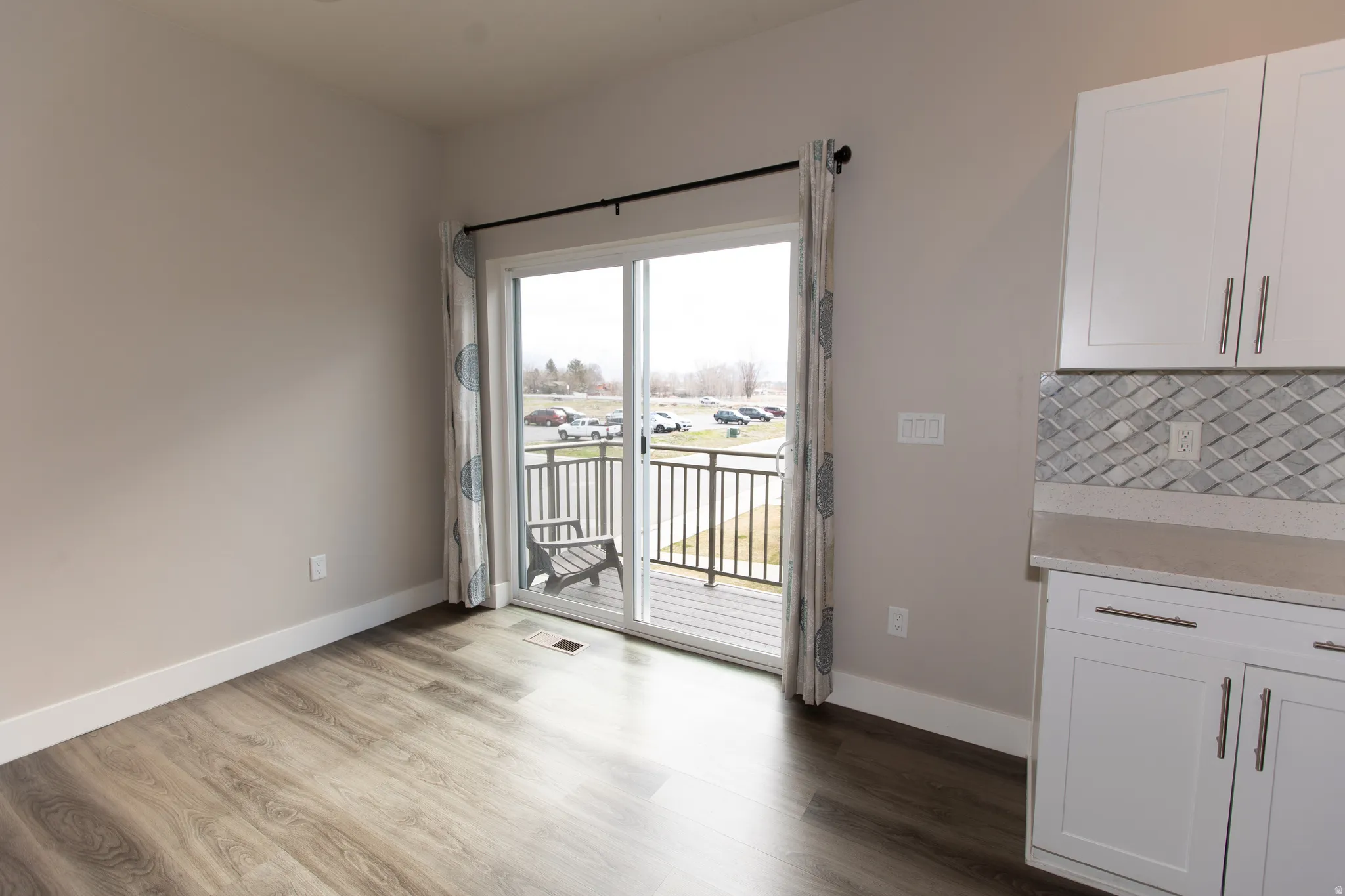 Unfurnished dining area with dark wood-style floors and baseboards