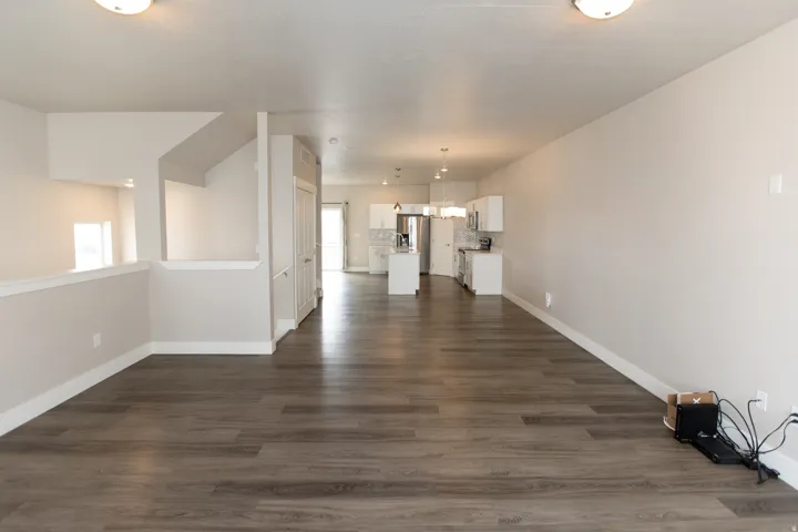 Spacious interior with wood-finish flooring, light neutral wall colors, and recessed lighting