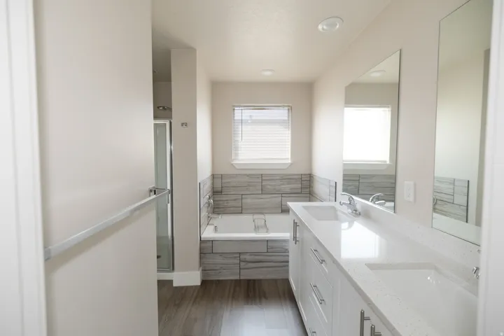 Dual vanity with integrated sinks, white cabinetry, and light-toned countertops