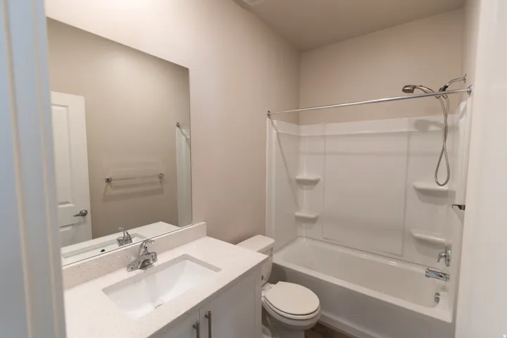 Bathroom with a white vanity, integrated sink, and light-toned countertop