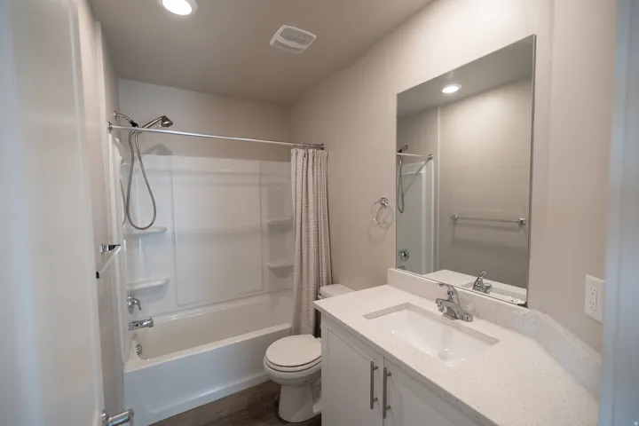 White vanity with a light-colored countertop, undermount sink, and chrome fixtures