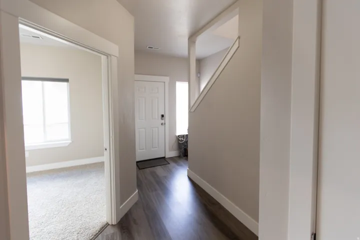 Entryway featuring wood-finish flooring, a paneled entry door, and a staircase with a half-wall railing