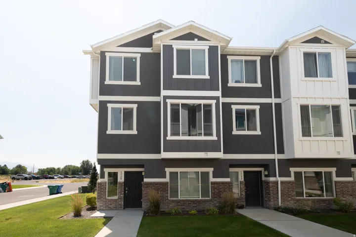 Modern multi-story exterior with dark gray siding and white trim