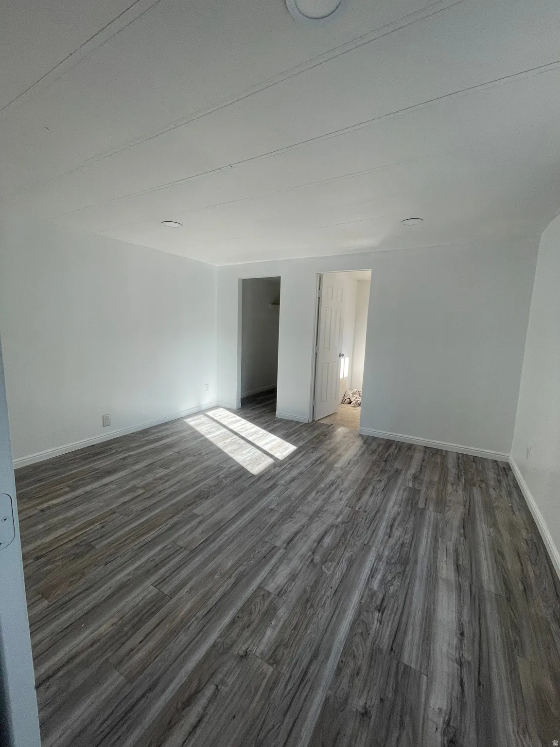 Unfurnished bedroom featuring dark wood-style floors