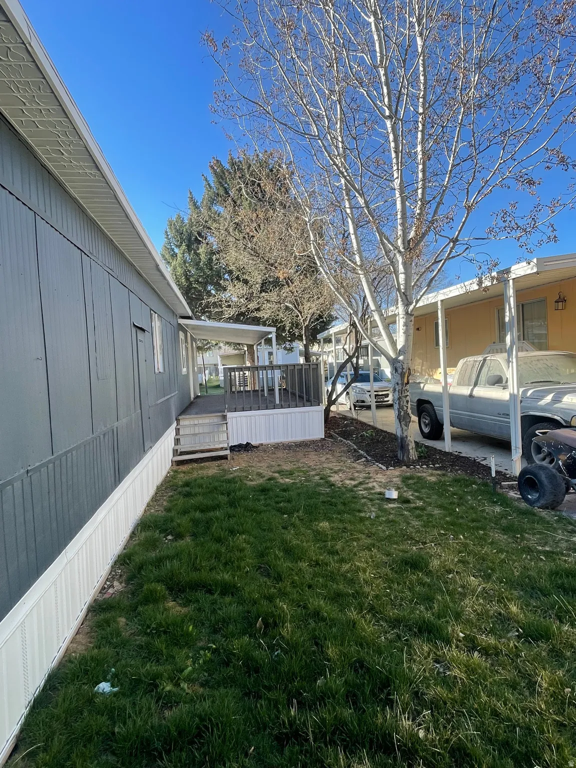View of grassy yard with a wooden deck