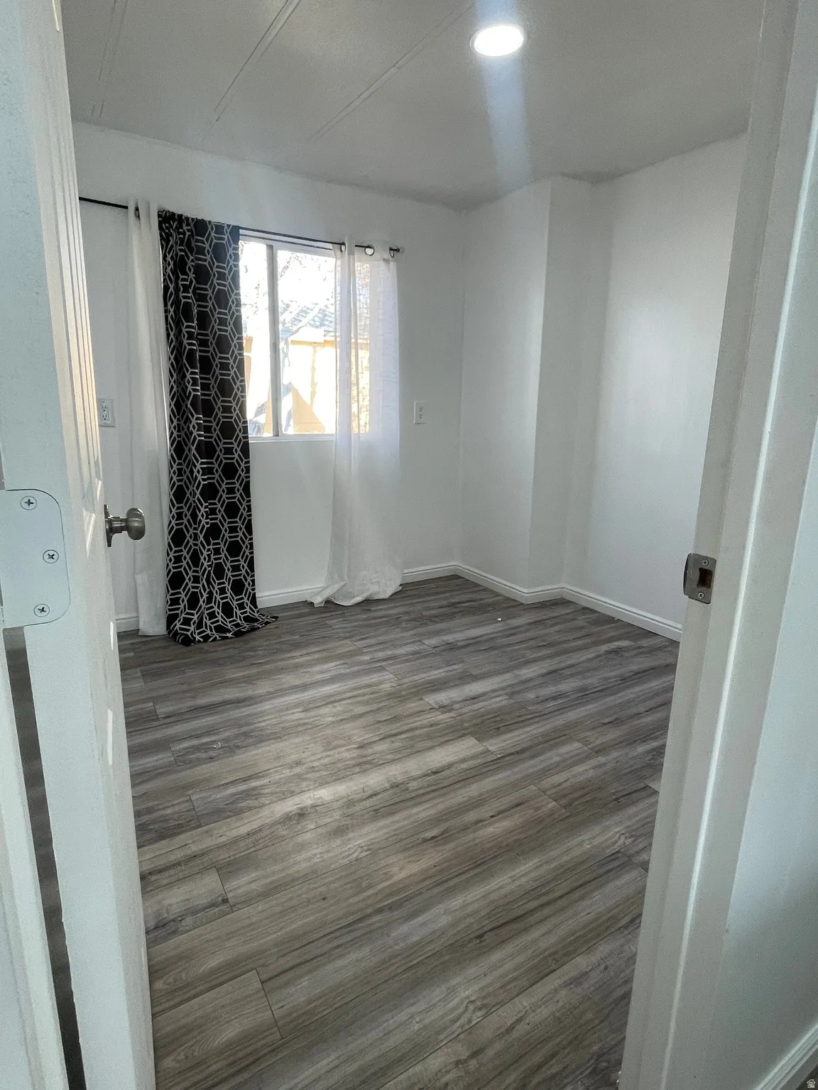 Unfurnished room featuring dark wood finished floors and baseboards