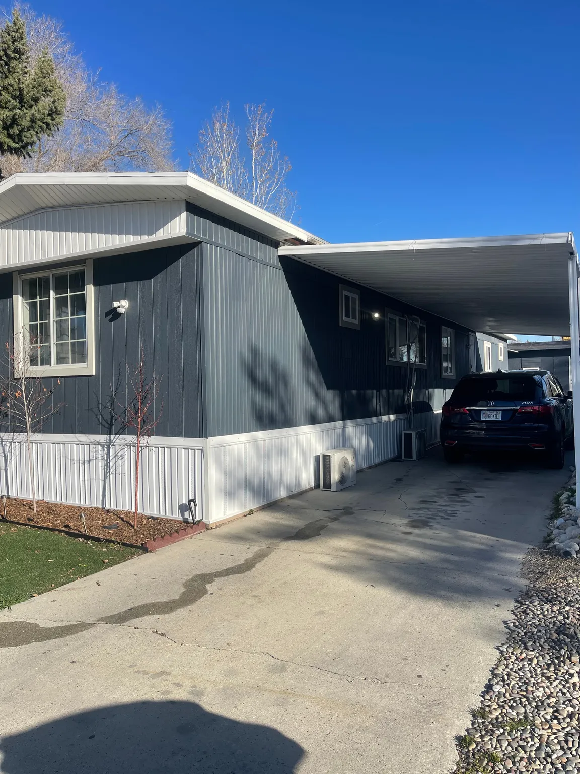 View of side of property featuring a carport and concrete driveway