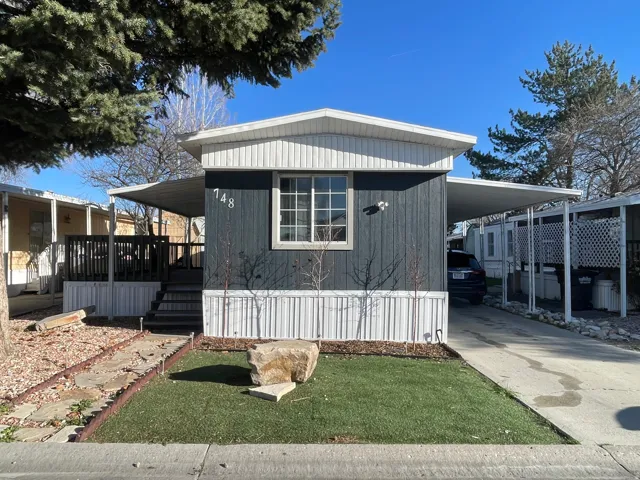 View of front of home with a carport, driveway, and a front yard